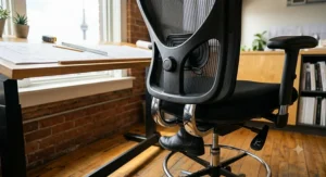 Close-up of ergonomic features including footrest and lumbar support on a high-quality drafting chair.